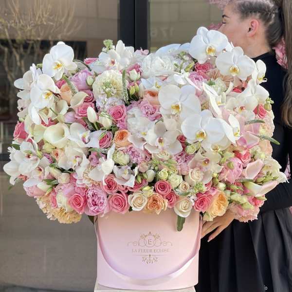 Large pink and white floral arrangement in a pastel box