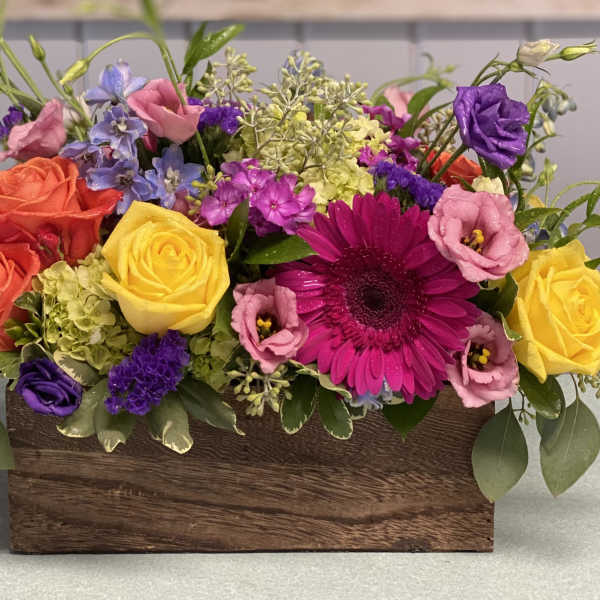 Colorful mixed flower arrangement in a wooden box