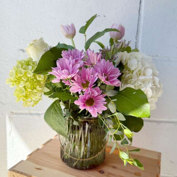 Pink daisies and hydrangeas in a glass vase