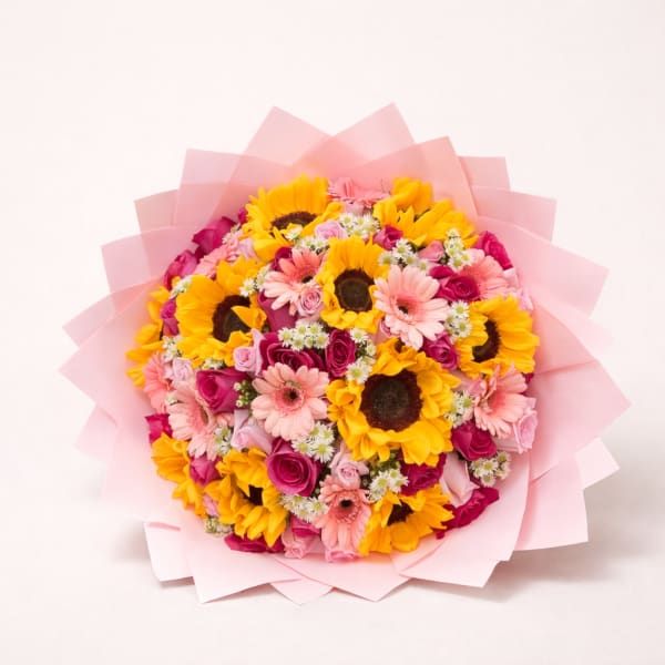 Bouquet of sunflowers, pink gerbera daisies, and roses wrapped in pink paper