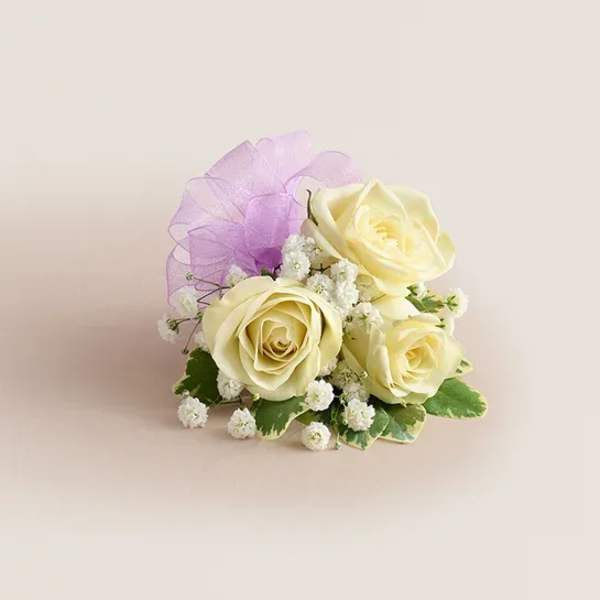 Cream roses with baby's breath and a purple ribbon accent