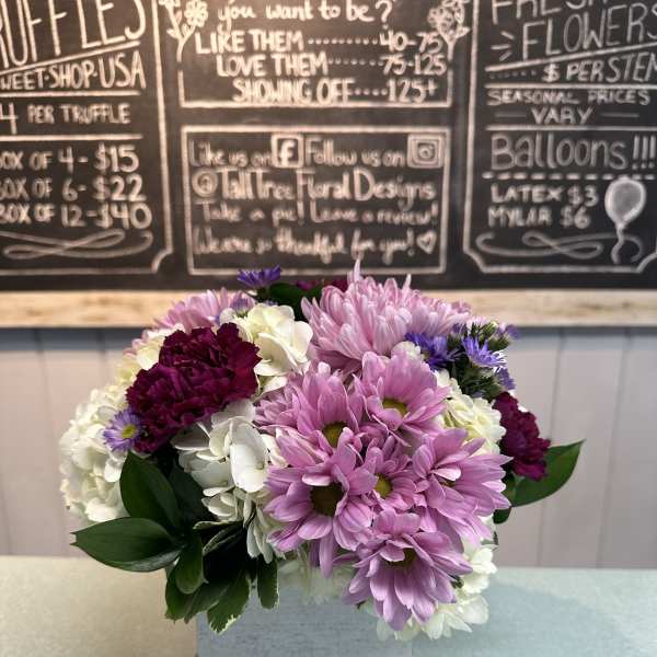 Pink and white daisy bouquet in a square white vase