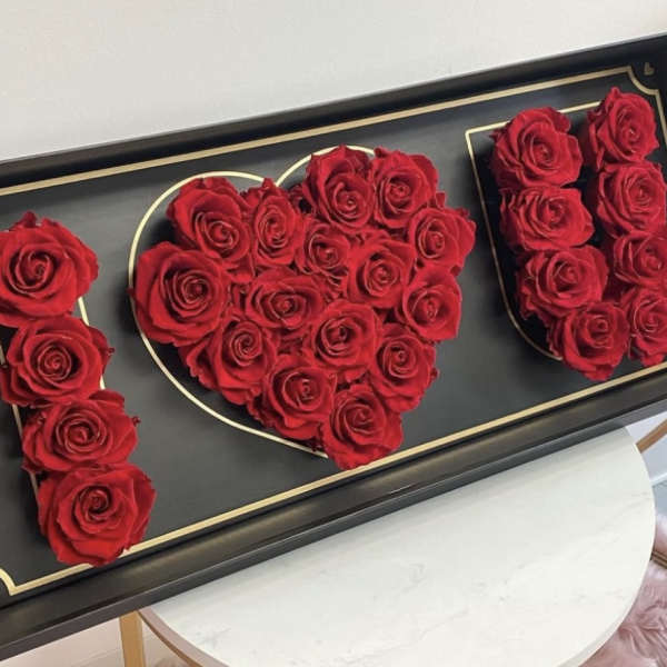 Red roses arranged in a black box to spell "I ♥ U"