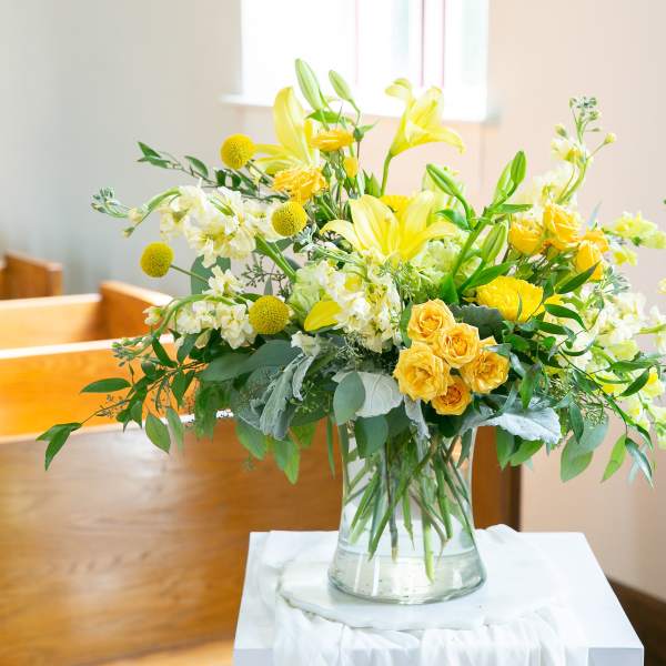 Yellow and white floral arrangement in a clear glass vase
