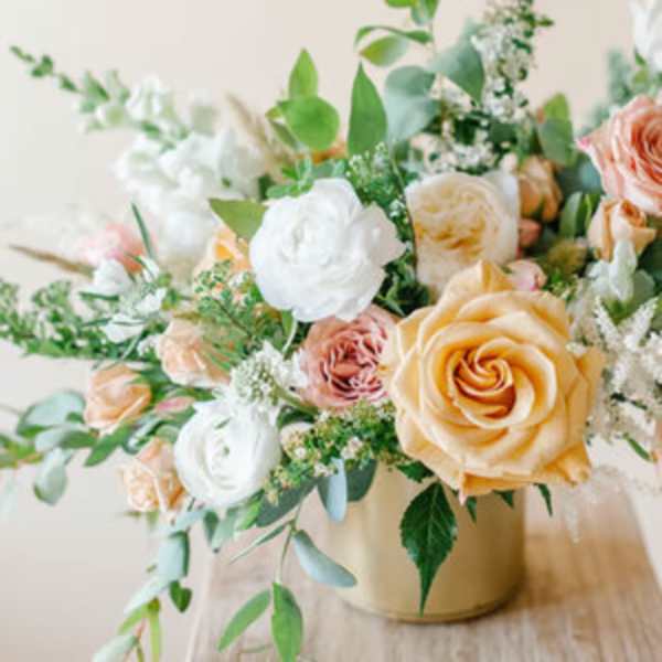 Peach and white rose bouquet in a gold vase