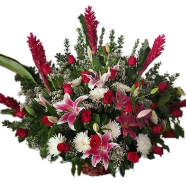 Large basket arrangement of red roses, pink lilies, and white mums with tall red tropical blooms