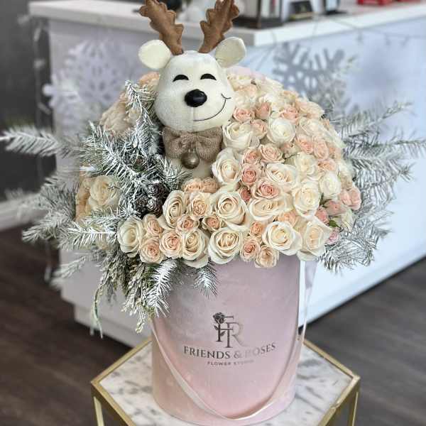 Cream and blush roses with a plush reindeer topper in a pink hatbox