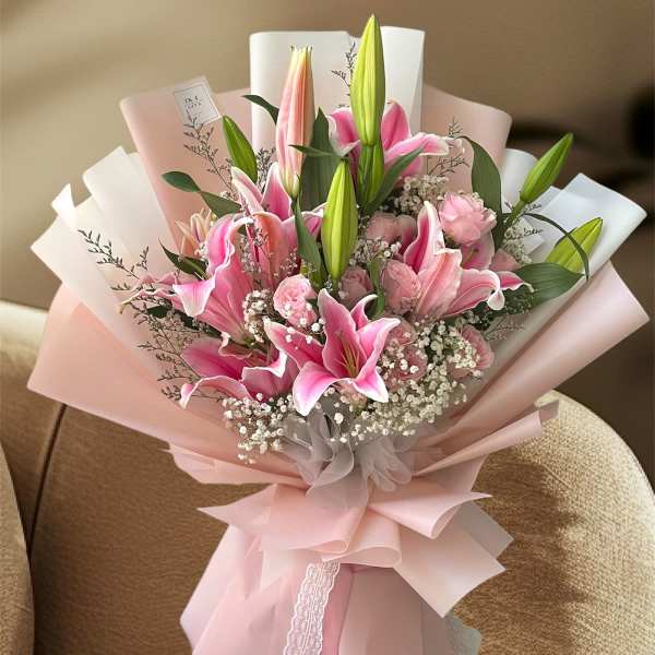 Pink lilies and roses wrapped in pale pink paper