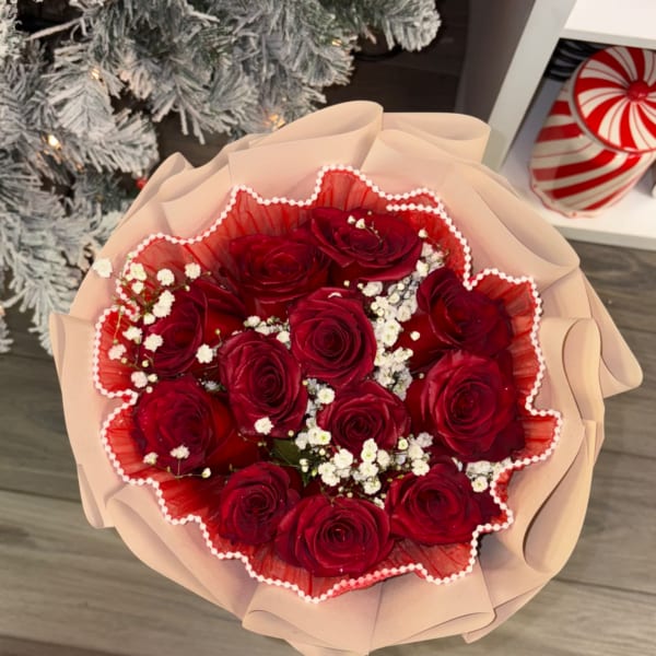 Bouquet of red roses with white baby's breath in pink wrapping