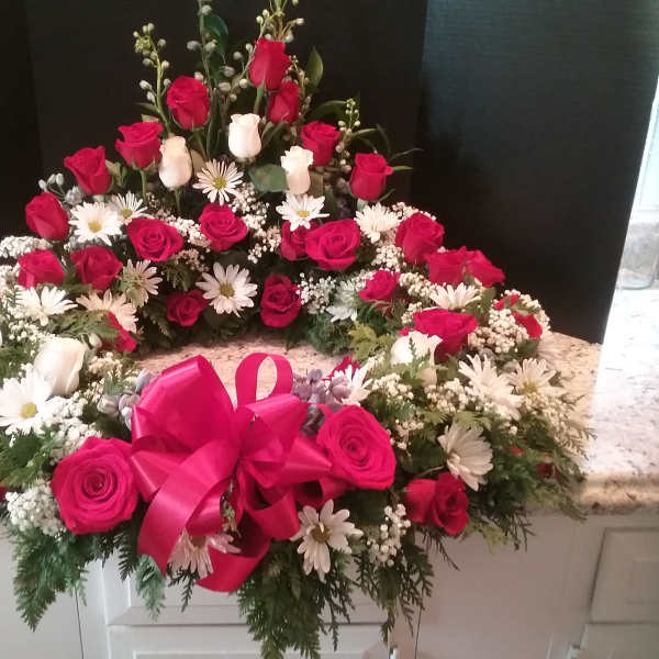 Heart-shaped floral wreath with red and white roses and daisies