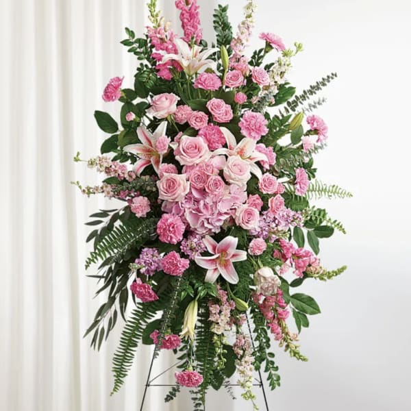 Tall pink floral standing spray on an easel with lilies and roses
