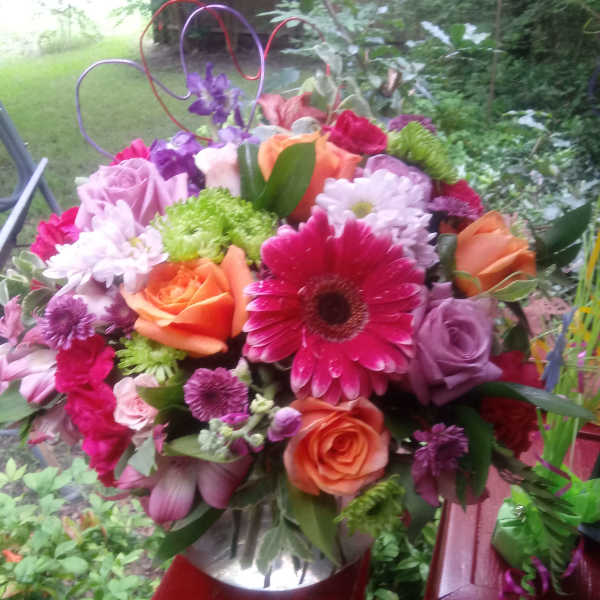 Mixed bouquet with roses, gerbera daisies, and chrysanthemums in bright pink, orange, and purple