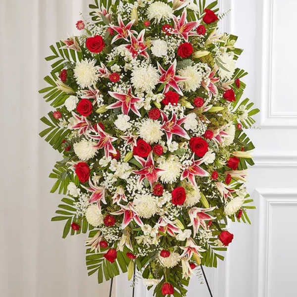 Large standing floral spray with red roses, white blooms, and pink lilies