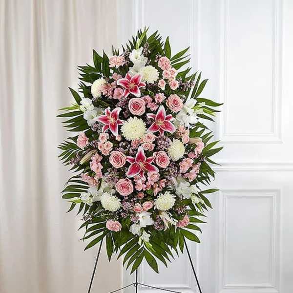 Standing floral spray with pink and white flowers on a black easel