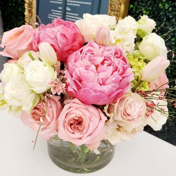 Pink and white bouquet of roses and peonies in a glass vase