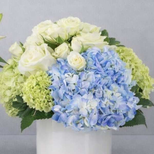 Blue and white flower arrangement in a white vase