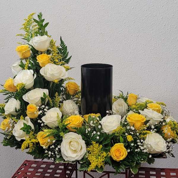 White and yellow roses arranged around a black vase