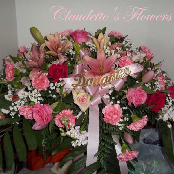 Pink and red floral arrangement with lilies, roses, and carnations