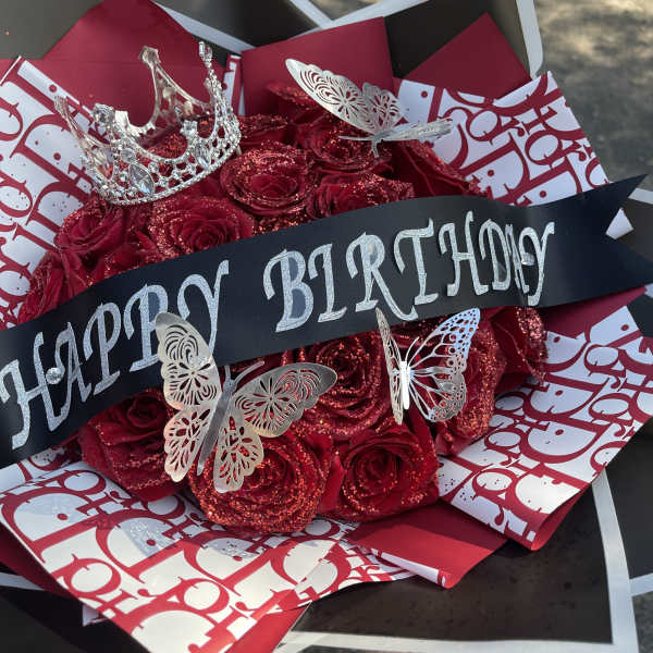 Red rose bouquet with a birthday ribbon and silver crown toppers