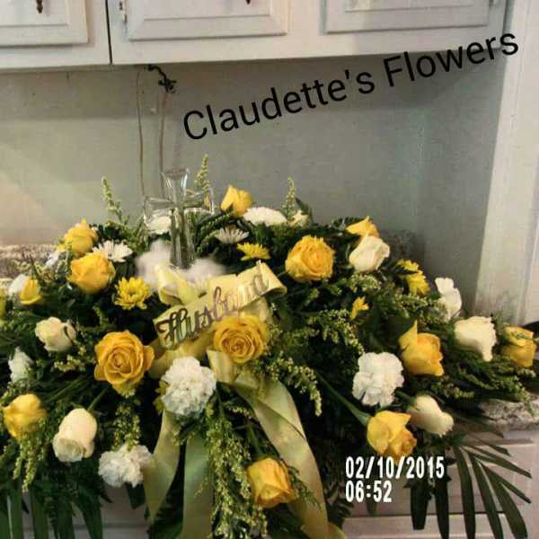 Yellow and white rose casket spray with a cross centerpiece