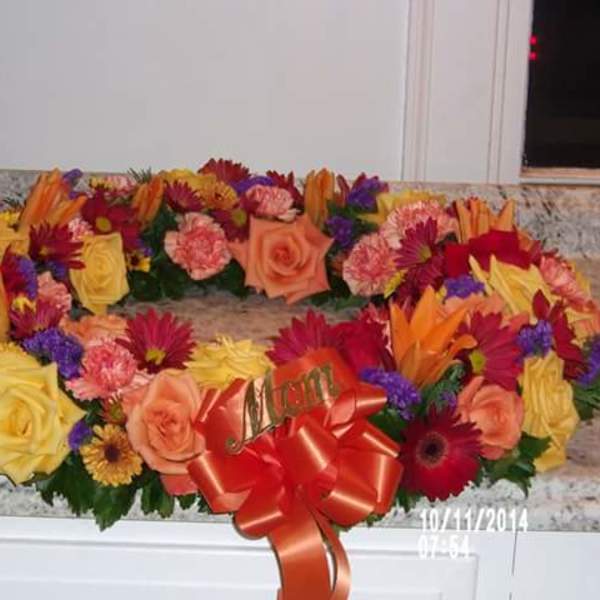Colorful floral wreath with roses, carnations, and daisies on a countertop