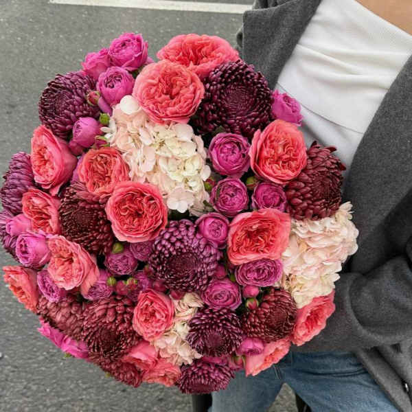 Large bouquet of pink and burgundy flowers with white hydrangea clusters