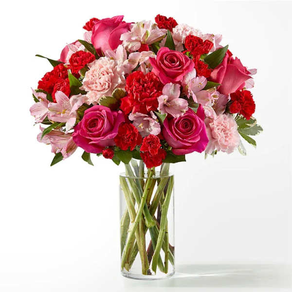 Bouquet of pink roses, carnations, and alstroemeria in a clear glass vase