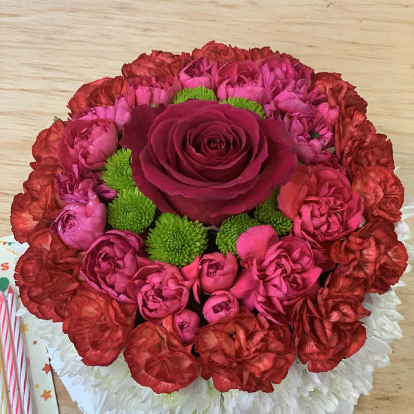 Round bouquet of red and pink flowers with a central rose