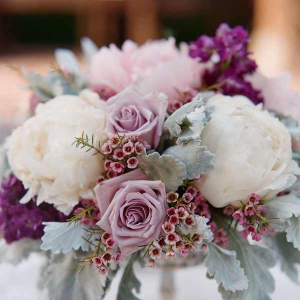 Lavender roses and white peonies in a low bouquet with silver foliage