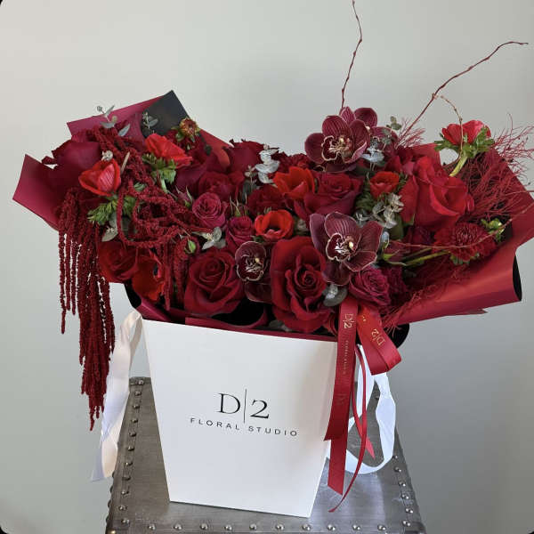 Red rose bouquet with orchids in a white gift box