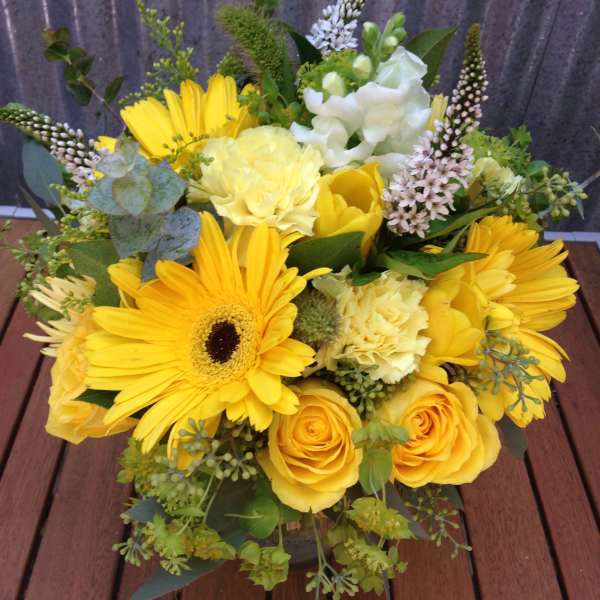 Yellow bouquet with gerbera daisies and roses in a low arrangement