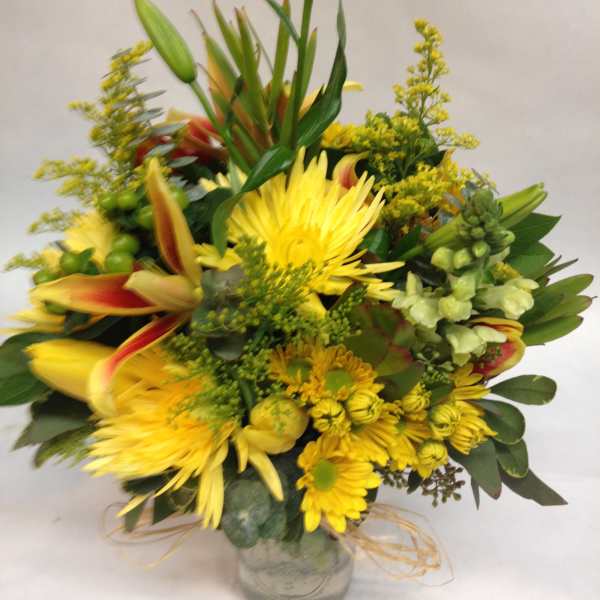Yellow mixed flower bouquet in a clear glass vase