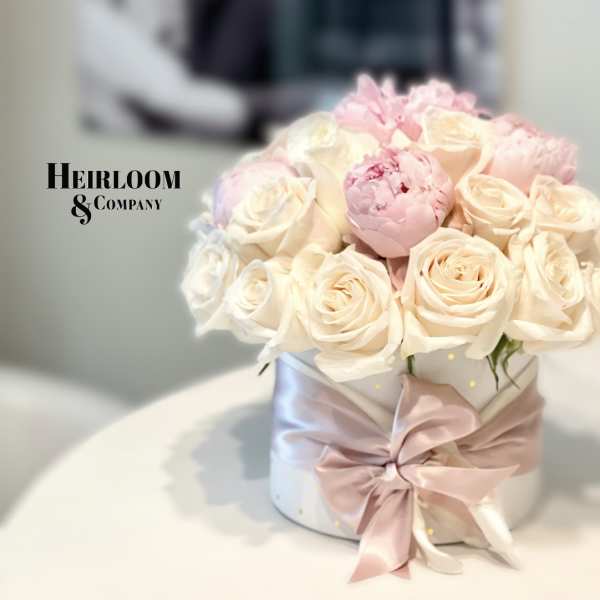 Blush and ivory rose bouquet in a white hatbox with a pink ribbon