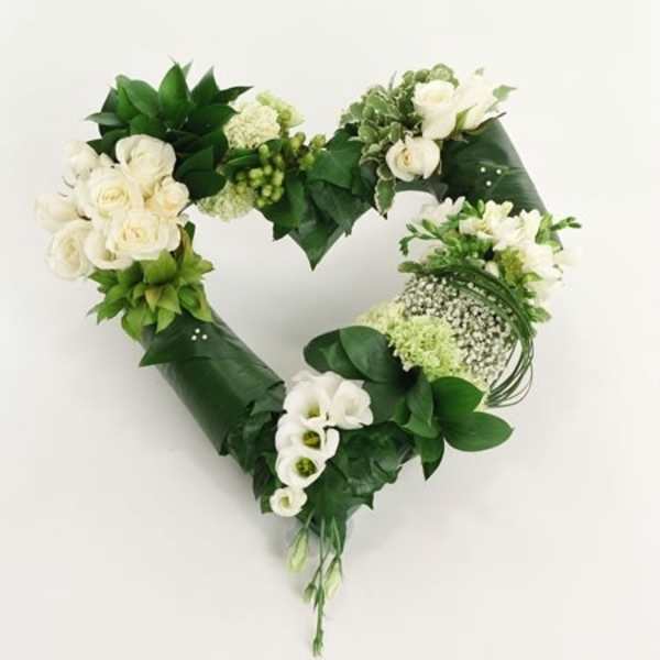 Heart-shaped floral wreath with white roses and green foliage