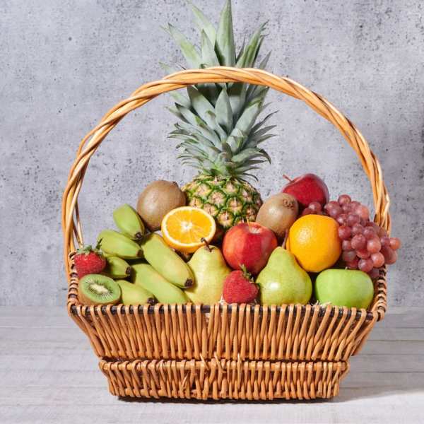 Wicker basket filled with assorted fruit and a pineapple centerpiece
