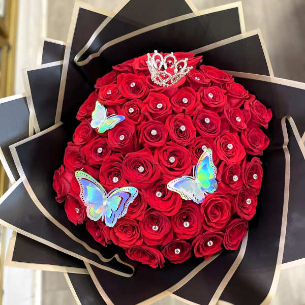 Bouquet of red roses with butterfly decorations and a small crown topper
