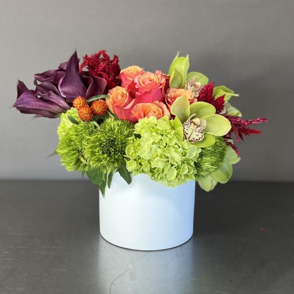 Colorful floral arrangement in a white cylindrical vase