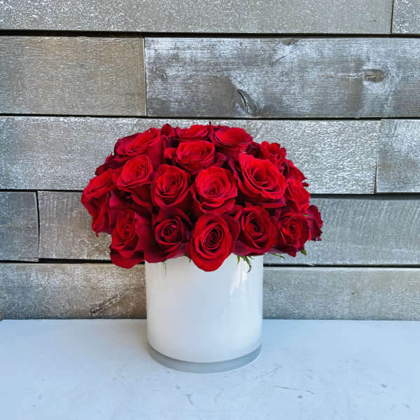 Red rose bouquet in a white cylindrical vase