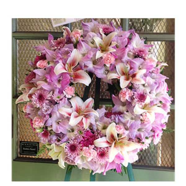 Pink and white floral wreath on a stand