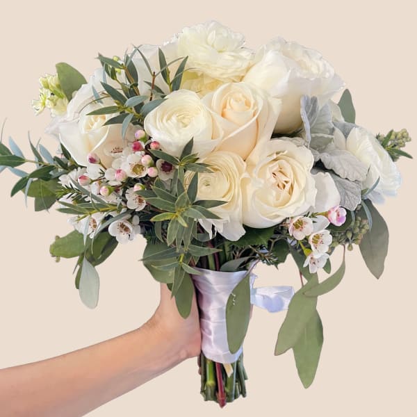 White rose bouquet with small blossoms and greenery, wrapped in satin ribbon
