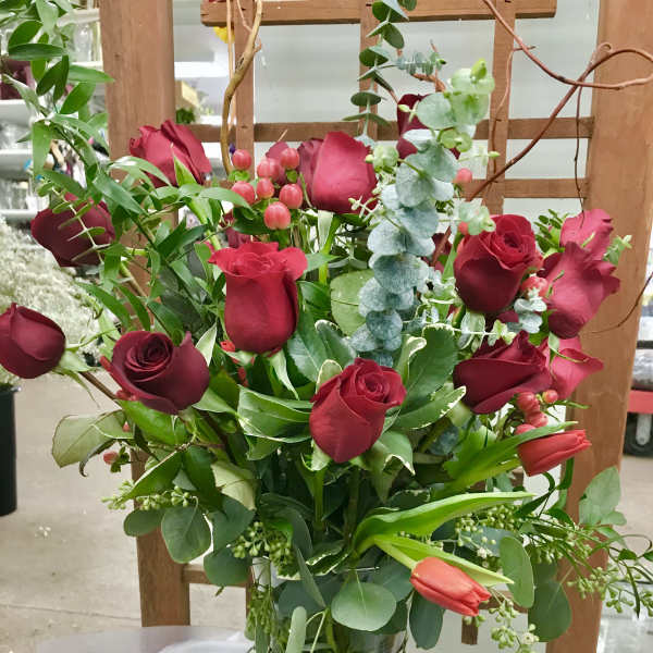 Bouquet of red roses and tulips in a glass vase