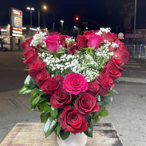 Bouquet of red roses and white baby's breath in a white vase