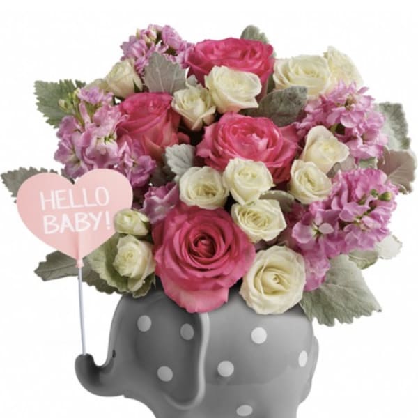 Pink and white roses in a gray polka-dot elephant planter with a "Hello Baby!" sign