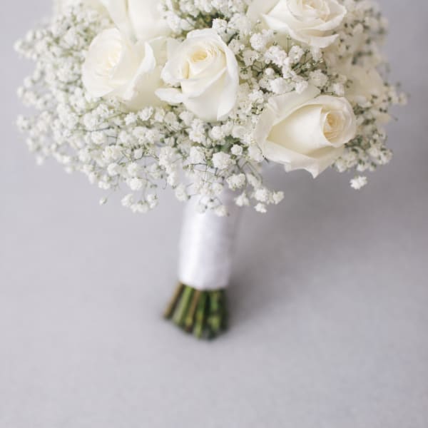 White rose bouquet with baby's breath and wrapped stems