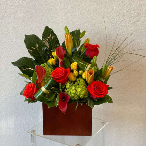 Red roses and calla lilies arranged in a wooden box