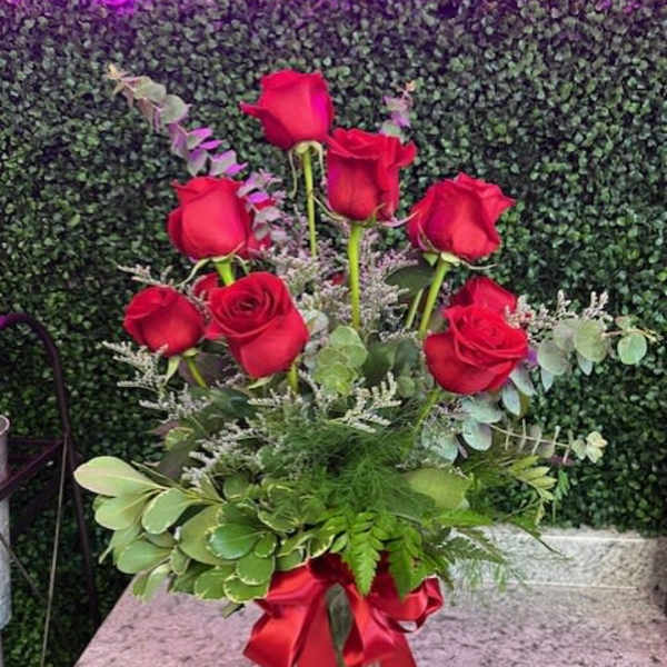 Red roses in a glass vase with a red ribbon
