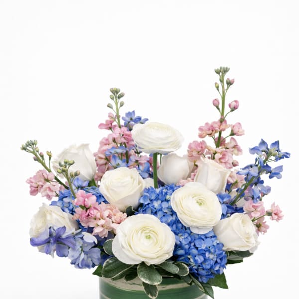 White roses and blue hydrangeas in a green striped vase