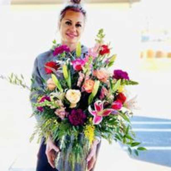 Woman holding a large mixed bouquet of colorful flowers