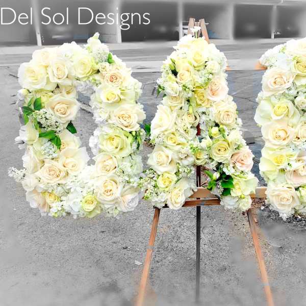 Large floral letters spelling "KAI" covered in white and cream roses