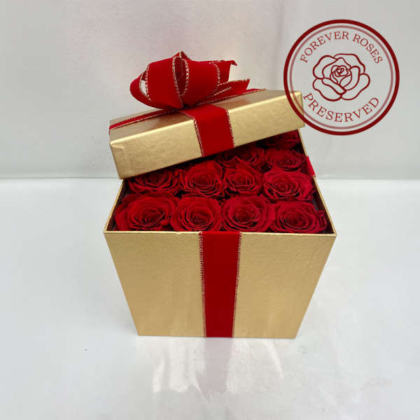 Gold gift box filled with red roses and tied with a red ribbon